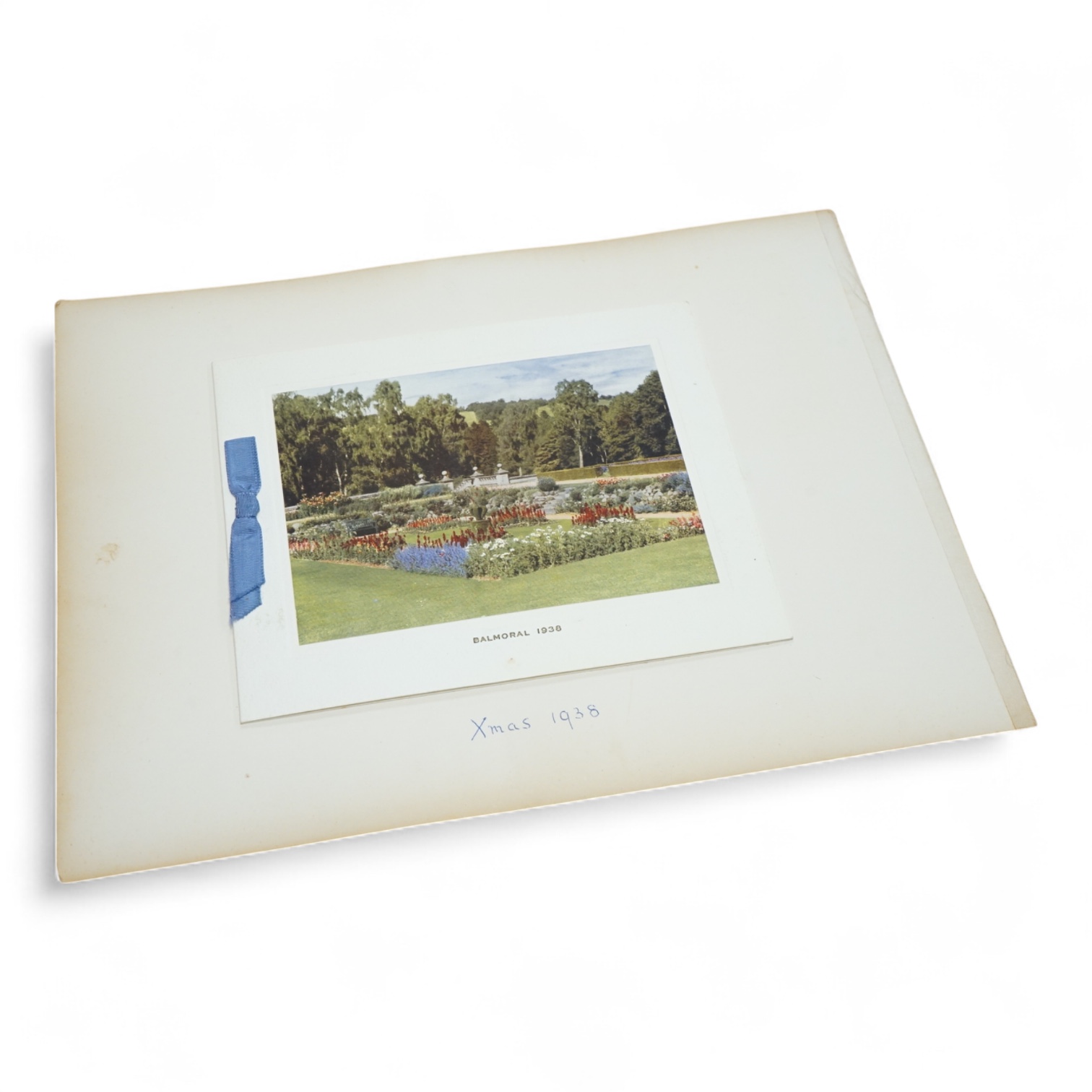 HRH King George VI and Queen Elizabeth signed Christmas card for 1938, with a colour photograph of the garden at Balmoral Castle entitled ‘Balmoral 1938’ to the cover, pasted onto a card leaf from a photograph/scrap albu